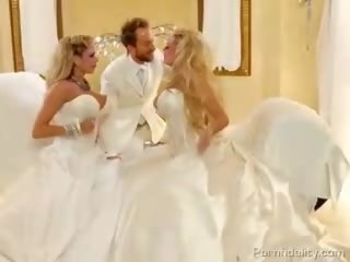 Dois blondies com enorme baloons em bridal dresses compartilhando um putz