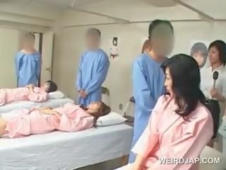 Aasialaiset ruskeaverikkö nuori nainen puhaltaa karvainen putz at the sairaalan
